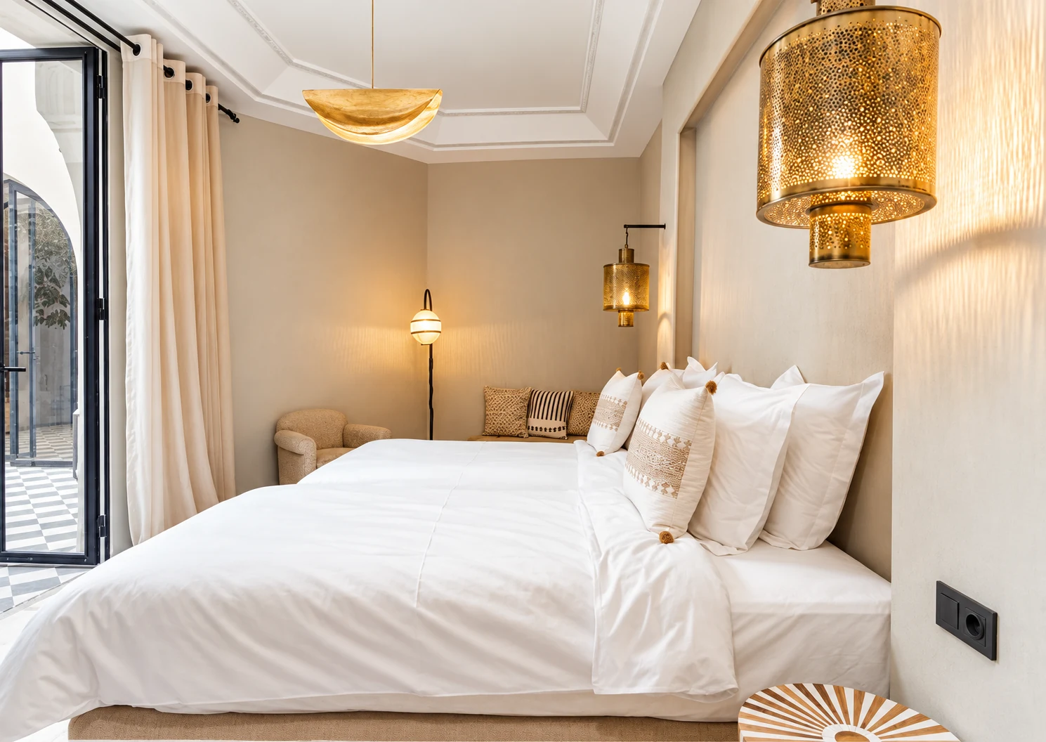 Chambre élégante aux tons chaleureux, avec un lit blanc et des luminaires dorés